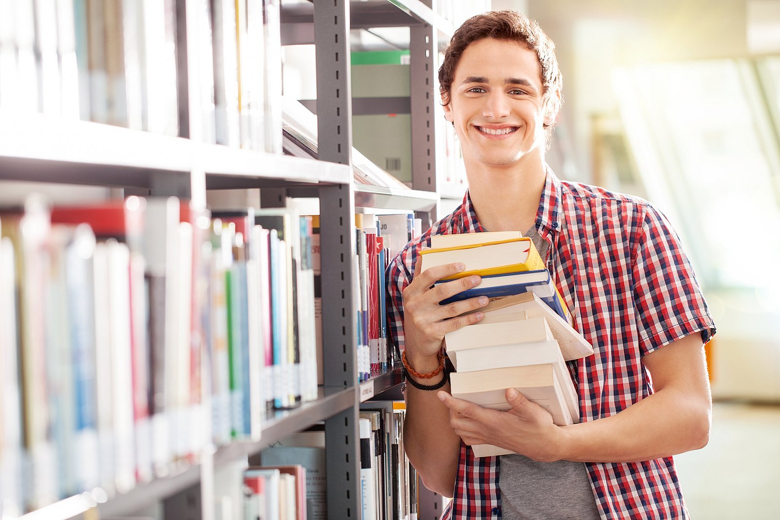Young student with books in library