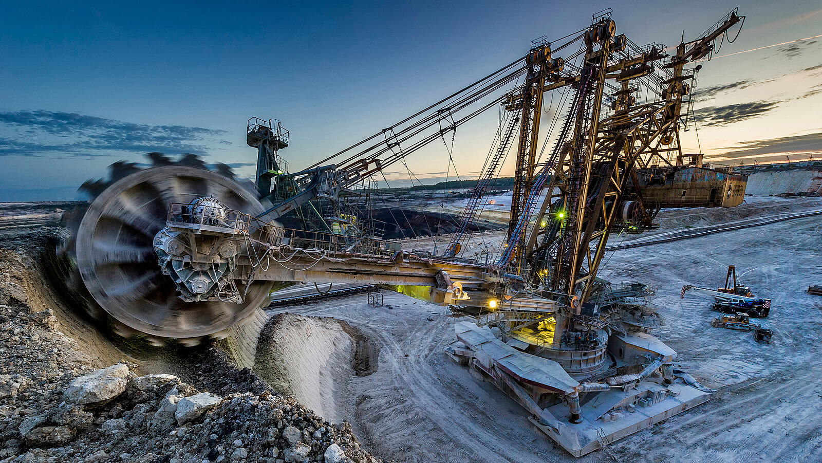 Rotary,Excavator.,Stoilensky,Mining,And,Processing,Plant,(sgok),Is,One Schaufelradbagger in einem Tagebau bei Dämmerung, umgeben von Abraumhalden.